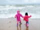 Kinder mit Regenkleidung an der Ostsee