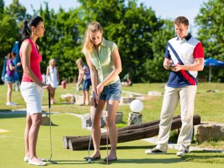 Urlauber spielen Minigolf
