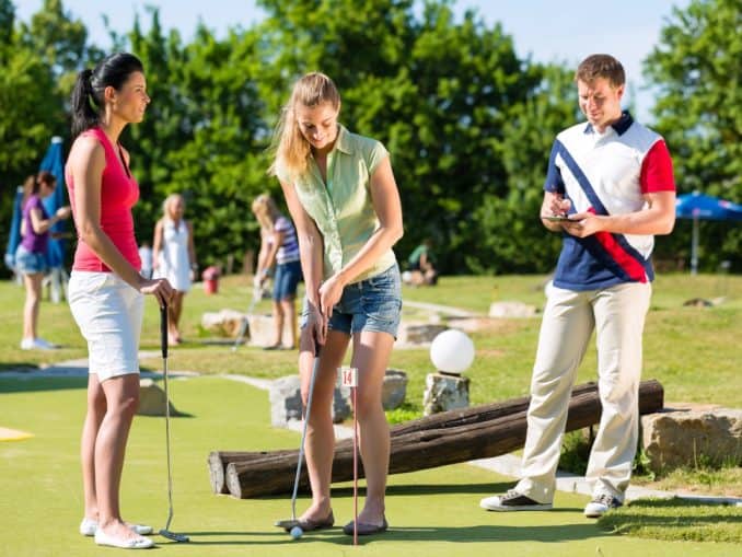 Urlauber spielen Minigolf