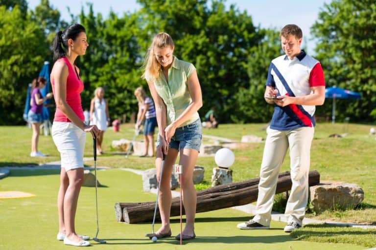 Urlauber spielen Minigolf