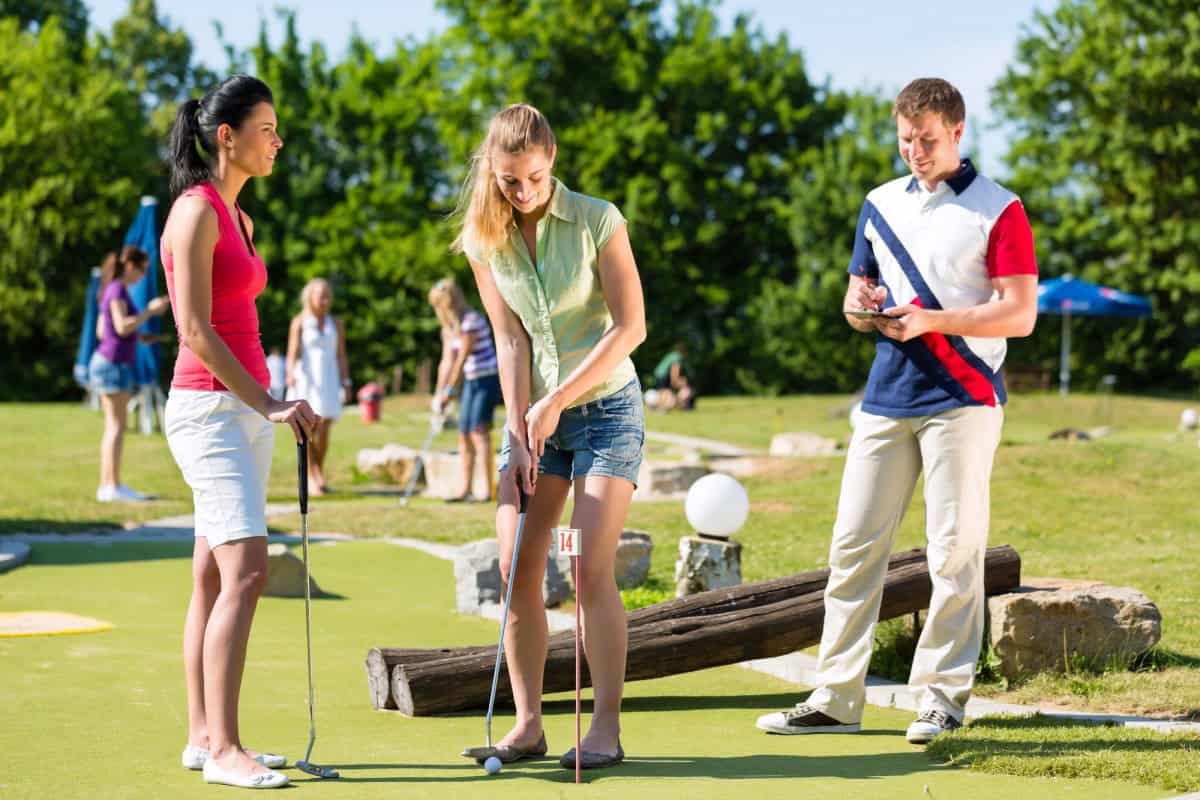 Urlauber spielen Minigolf