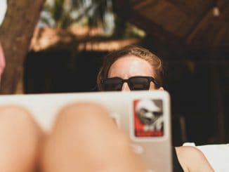 Frau mit Laptop am Strand