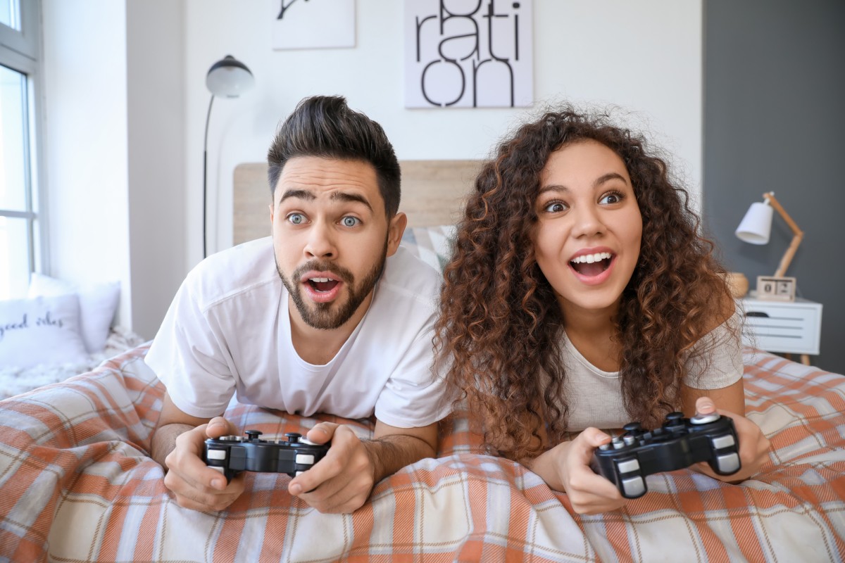 Kann ein verregneter Ostsee-Urlaub trotzdem erholsam sein? Junges Paar bei spielen